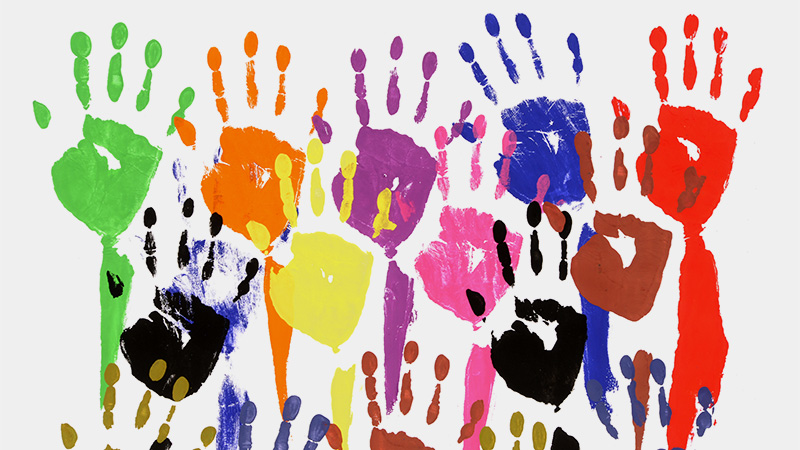 A wall of colourful children’s hand-prints (as if the children dipped first in different coloured paints and then pressed them onto the wall)